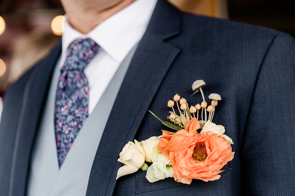  whimsical wedding at an ocean front venue with the groom in a mix and match look with navy and grey colors – groom close up