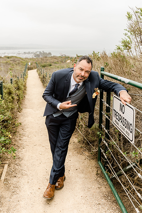  whimsical wedding at an ocean front venue with the groom in a mix and match look with navy and grey colors – groom 