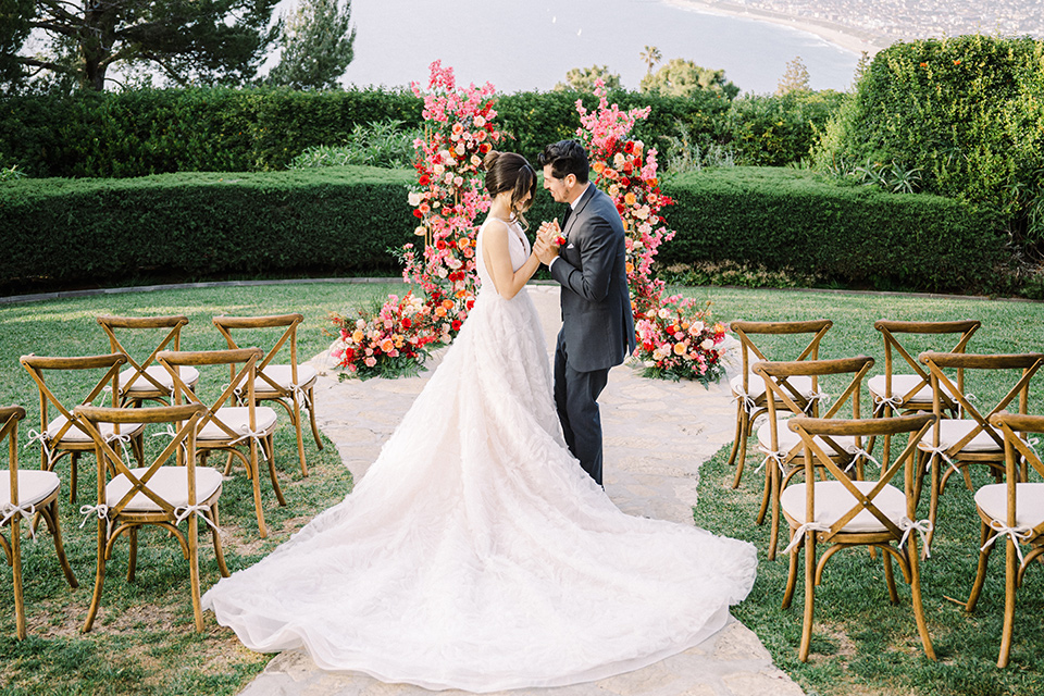  a Chinese-Spanish fusion wedding with the bride in a white flowing gown and the groom in a grey suit and burgundy velvet coat - ceremony 