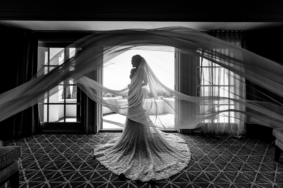  glitz and glam wedding by the beach with the bride in a lace crystal gown and the groom in a black tuxedo – bride getting ready