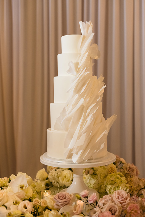  glitz and glam wedding by the beach with the bride in a lace crystal gown and the groom in a black tuxedo – wedding cake