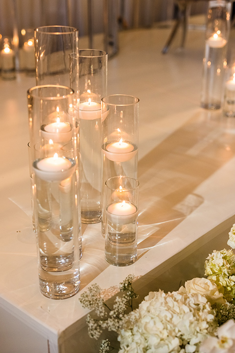  glitz and glam wedding by the beach with the bride in a lace crystal gown and the groom in a black tuxedo – wedding candles