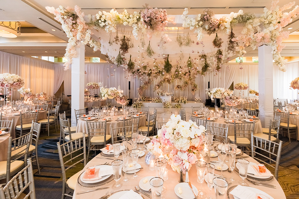  glitz and glam wedding by the beach with the bride in a lace crystal gown and the groom in a black tuxedo – reception decor