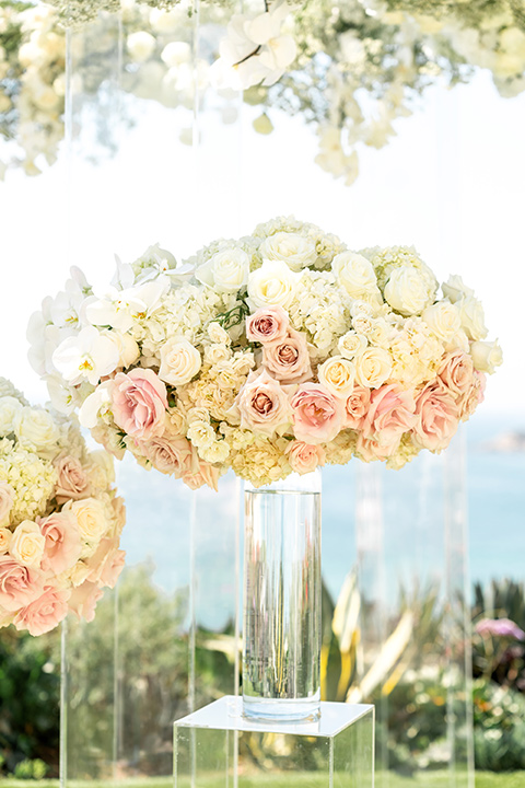  glitz and glam wedding by the beach with the bride in a lace crystal gown and the groom in a black tuxedo – wedding ceremony flowers