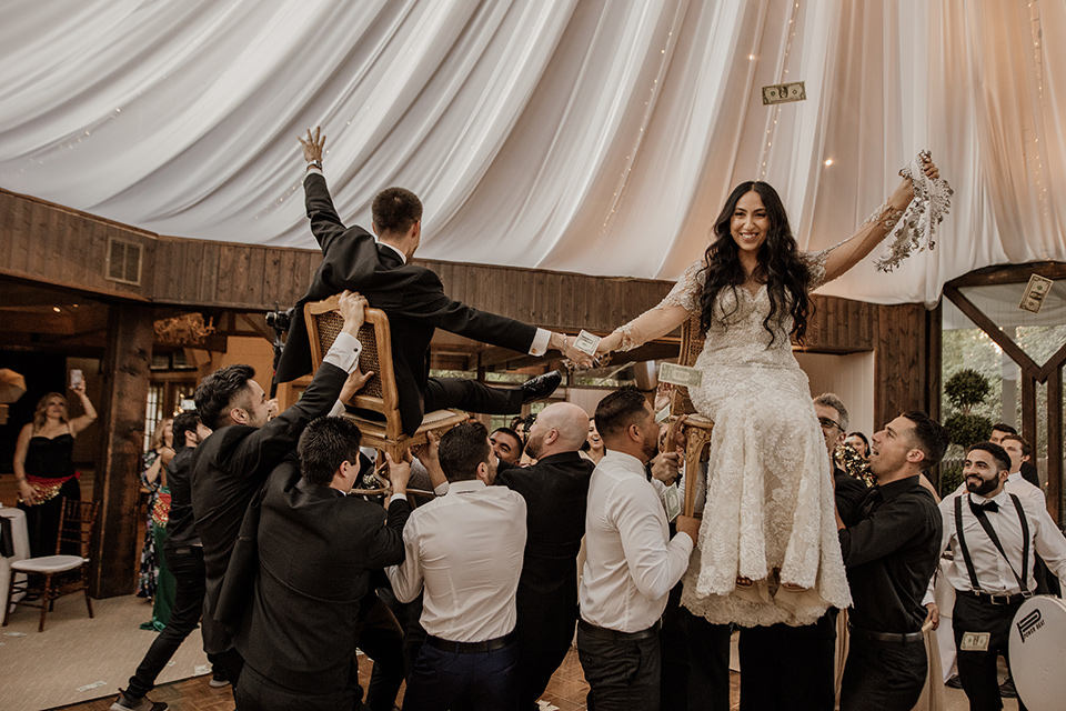  black and blush wedding with drums and star décor – couple being lifted up in chairs