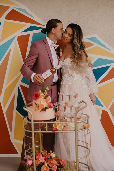  a funky groovy downtown palm springs wedding with bright colors and boho style - couple with champagne 