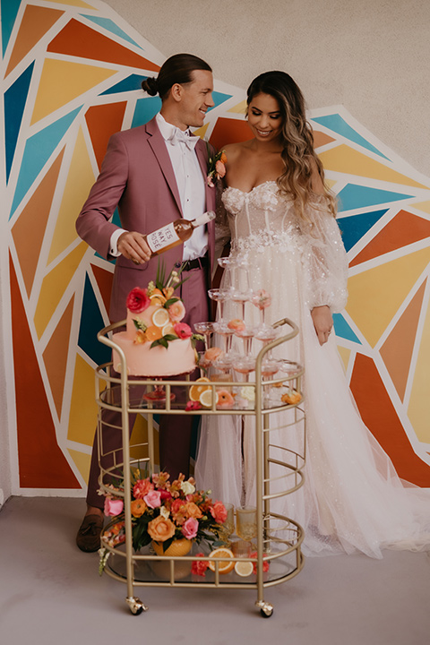 a funky groovy downtown palm springs wedding with bright colors and boho style - couple with champagne 
