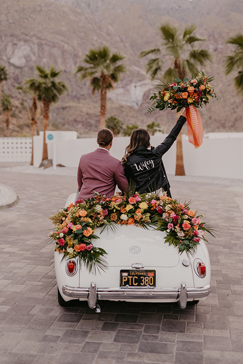  a funky groovy downtown palm springs wedding with bright colors and boho style - couple in car 