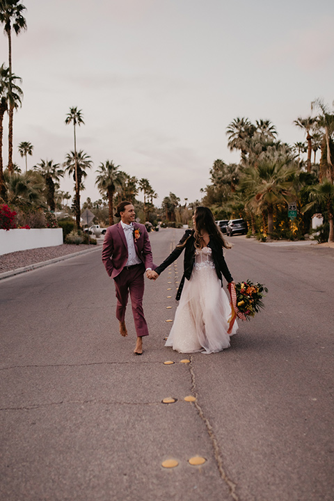  a funky groovy downtown palm springs wedding with bright colors and boho style - couple walking 