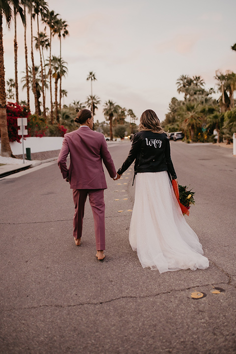 a funky groovy downtown palm springs wedding with bright colors and boho style - couple walking 