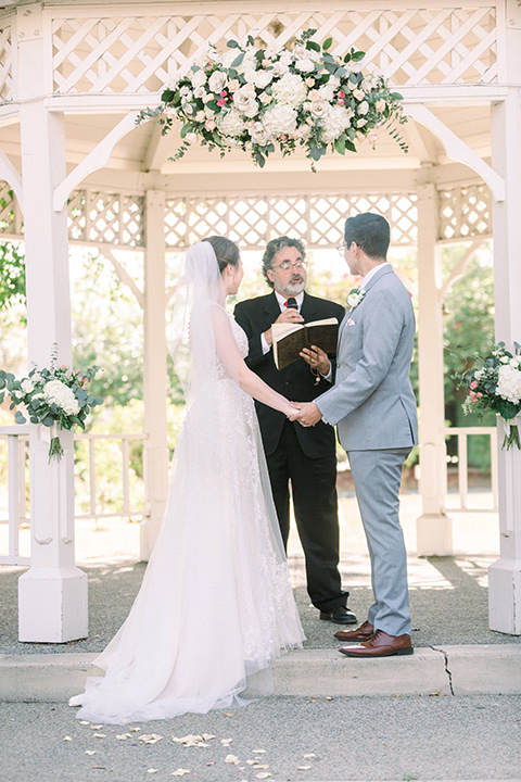  a romantic garden wedding with grey and pink décor and style, with the bride in a gorgeous white gown and the groom in a heather grey suit, the bridesmaids were in blush pink gowns and the groomsmen in heather grey suits - ceremony