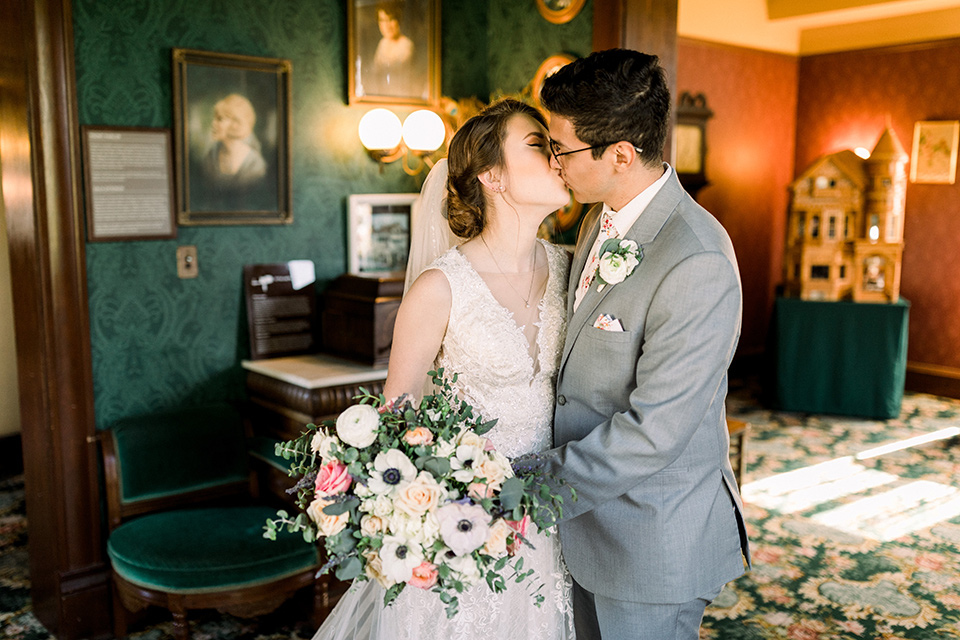  a romantic garden wedding with grey and pink décor and style, with the bride in a gorgeous white gown and the groom in a heather grey suit, the bridesmaids were in blush pink gowns and the groomsmen in heather grey suits – kissing