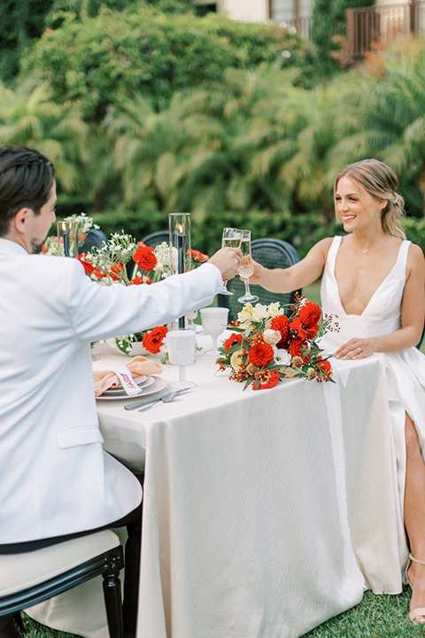  modern white and black wedding with pops of red – couple at the reception table 