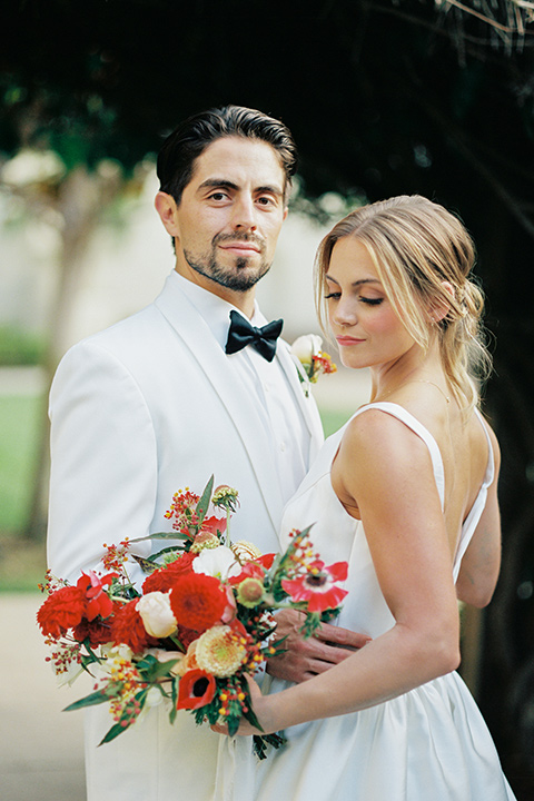  modern white and black wedding with pops of red – couple at ceremony 