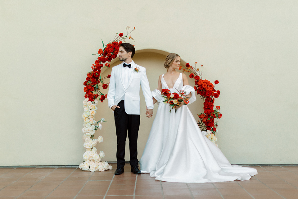  modern white and black wedding with pops of red – couple at ceremony 