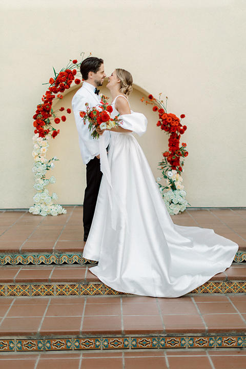  modern white and black wedding with pops of red – couple at ceremony 