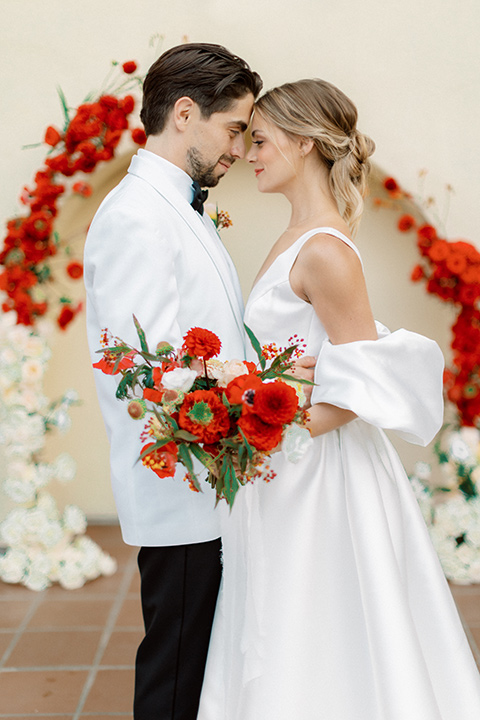  modern white and black wedding with pops of red – couple at ceremony 