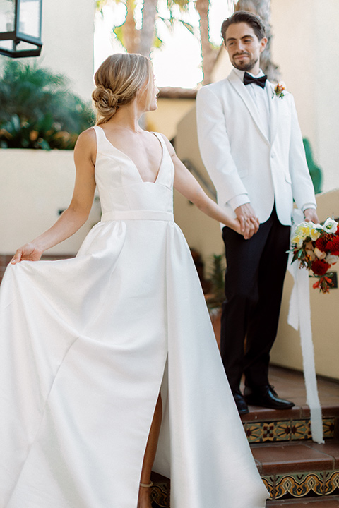  modern white and black wedding with pops of red – couple walking down the stairs 