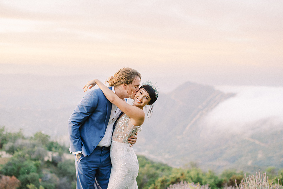  feminine spring editorial at a villa and the groom in a steel blue suit – couple embracing 
