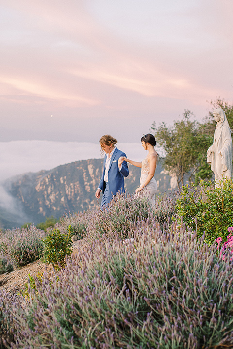  black and white beach wedding with lux details – couple walking on the mountains 