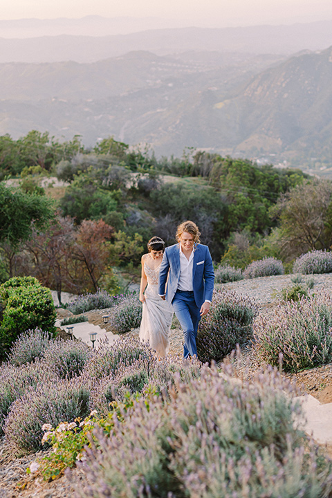  black and white beach wedding with lux details – couple walking on the mountains 