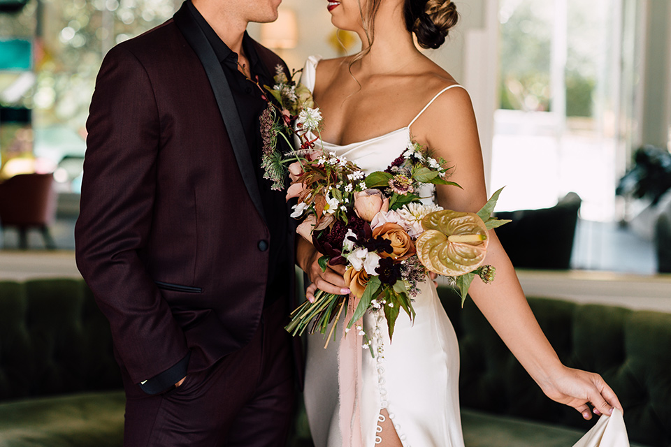  fig house shoot with burgundy and yellow details and the groom in a burgundy tuxedo – couple close up 