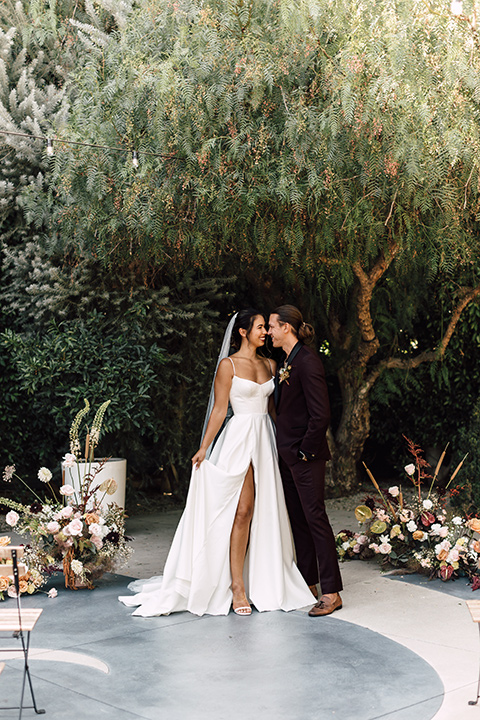  fig house shoot with burgundy and yellow details and the groom in a burgundy tuxedo – couple at ceremony 