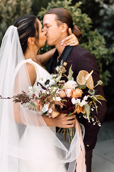  fig house shoot with burgundy and yellow details and the groom in a burgundy tuxedo – first kiss 