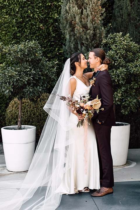 fig house shoot with burgundy and yellow details and the groom in a burgundy tuxedo – first kiss 