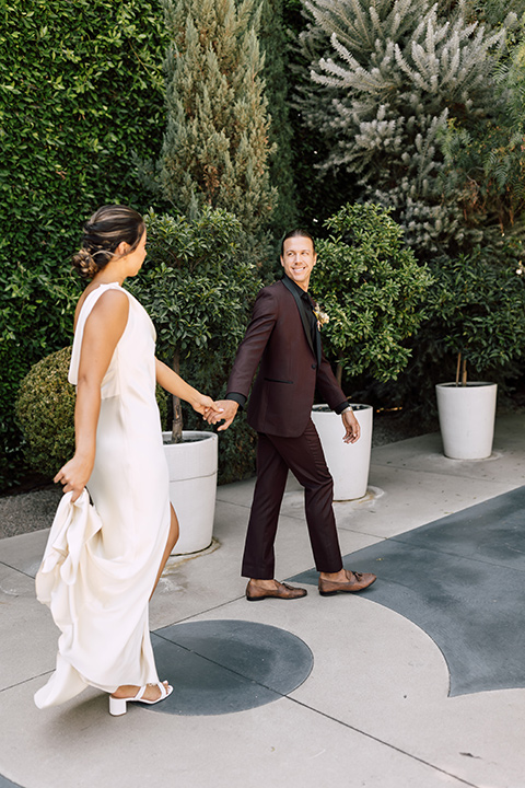  fig house shoot with burgundy and yellow details and the groom in a burgundy tuxedo – couple walking 