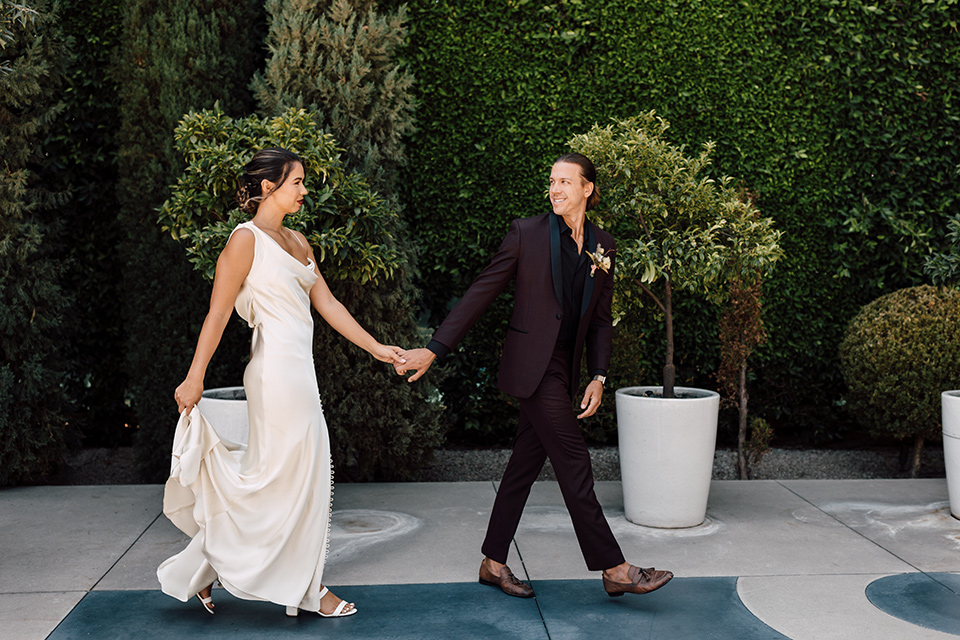  fig house shoot with burgundy and yellow details and the groom in a burgundy tuxedo – couple walking 
