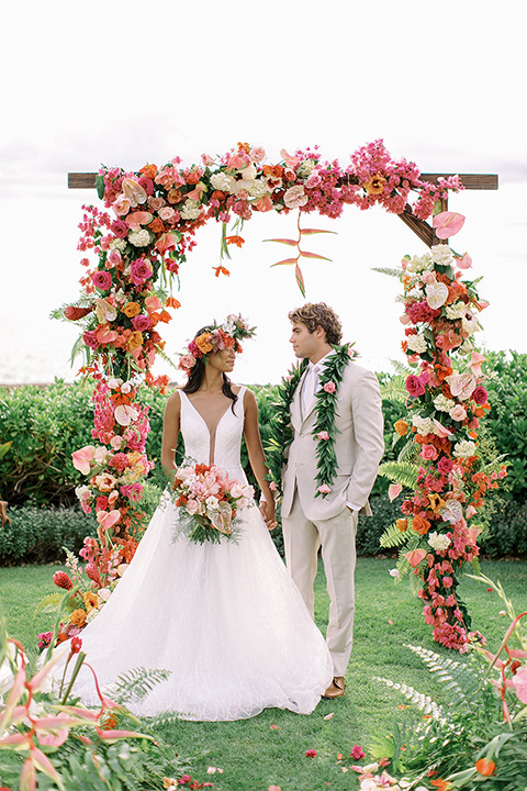  tropical tan and berry colored wedding in Hawaii – couple walking on grass 