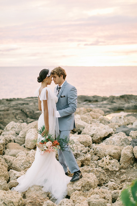  tropical tan and berry colored wedding in Hawaii – couple on arch 