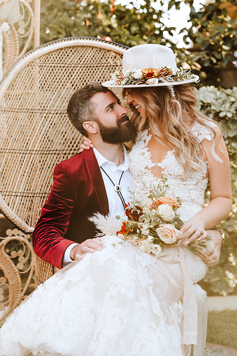  a burgundy and teal industrial winter wedding - couple sitting in boho chairs 