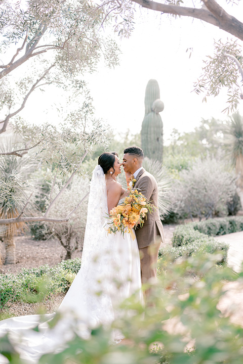  a golden toned wedding with garden details in Arizona - couple kissing in the grasses 