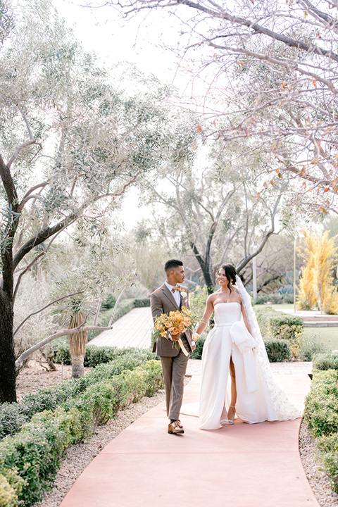  a golden toned wedding with garden details in Arizona - couple walking 