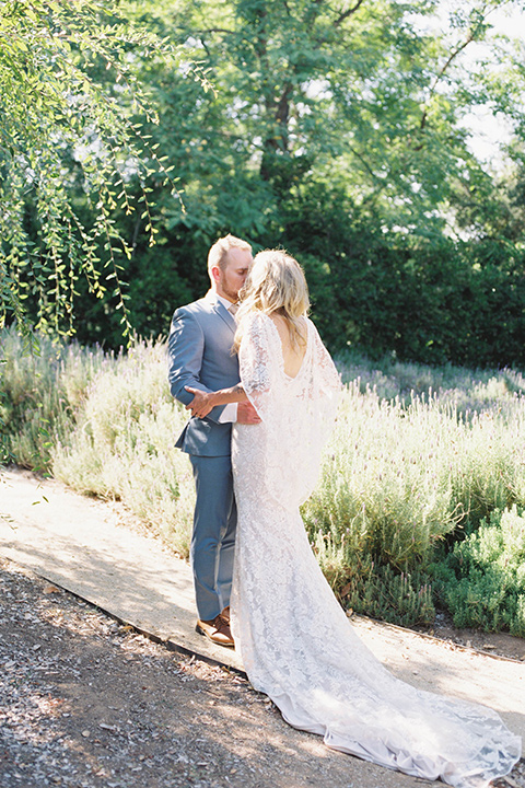  light blue and pink wedding with the groom in a light blue suit and the bride in a lace gown – couple walking down the aisle 