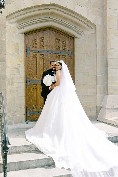  a royal black and rose grand wedding – couple outside the church 