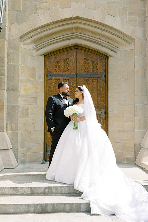  a royal black and rose grand wedding – couple outside the church 