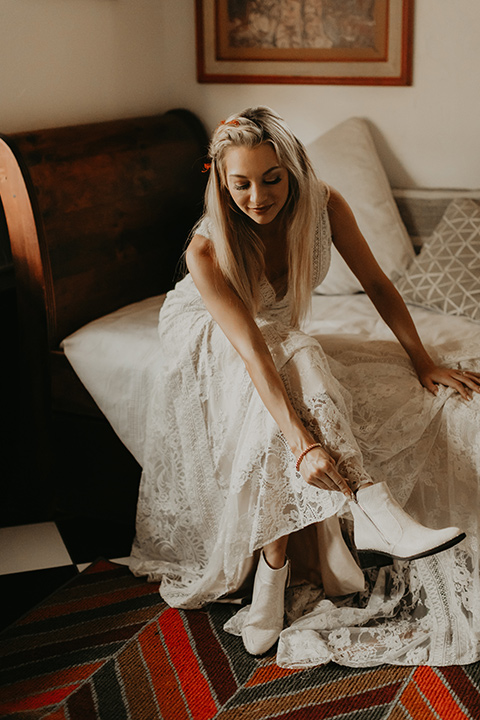  joshua tree wedding with the groom in a gold velvet tuxedo and a black tuxedo and the bride in a flowing gown with bridal wings – bride getting ready 