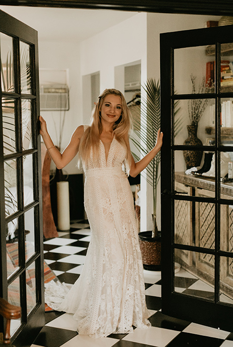  joshua tree wedding with the groom in a gold velvet tuxedo and a black tuxedo and the bride in a flowing gown with bridal wings – bride getting ready