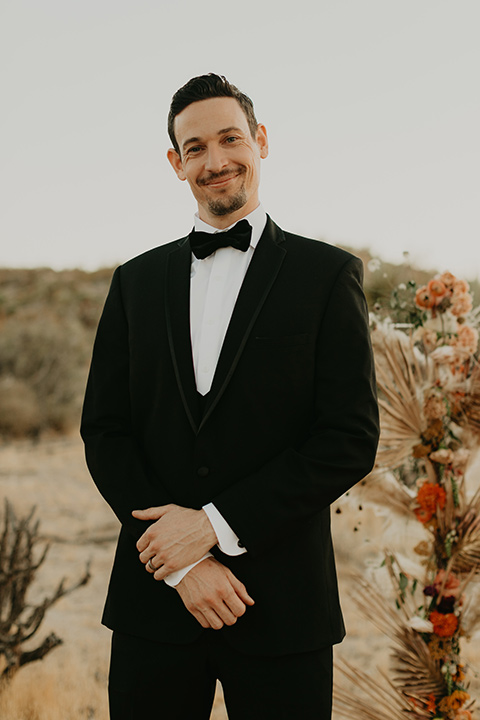  joshua tree wedding with the groom in a gold velvet tuxedo and a black tuxedo and the bride in a flowing gown with bridal wings – groom 