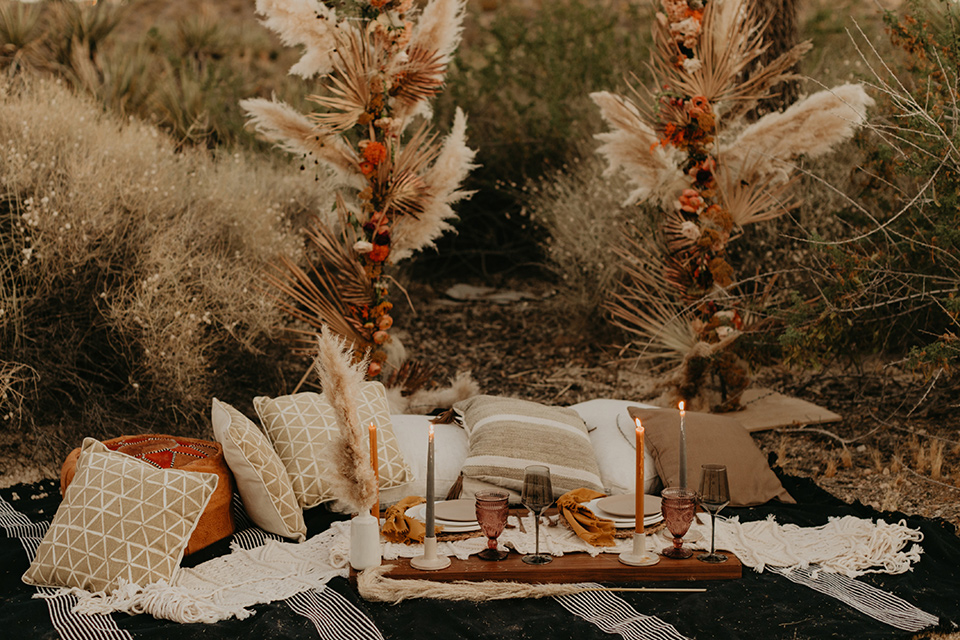  joshua tree wedding with the groom in a gold velvet tuxedo and a black tuxedo and the bride in a flowing gown with bridal wings – reception decor