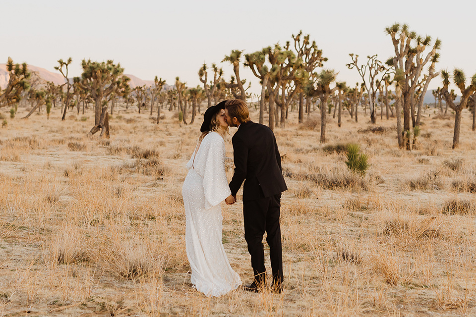  Joshua tree elopement with the bride in a sparkly gown and the groom in a black tuxedo – couple kissing