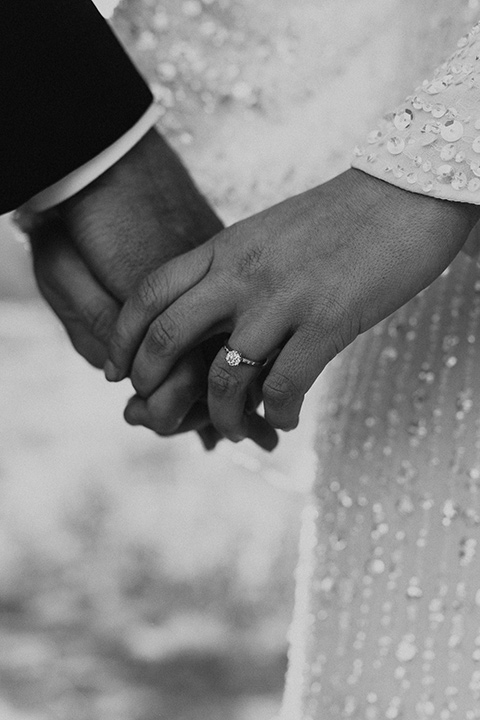  Joshua tree elopement with the bride in a sparkly gown and the groom in a black tuxedo– close up on hands 