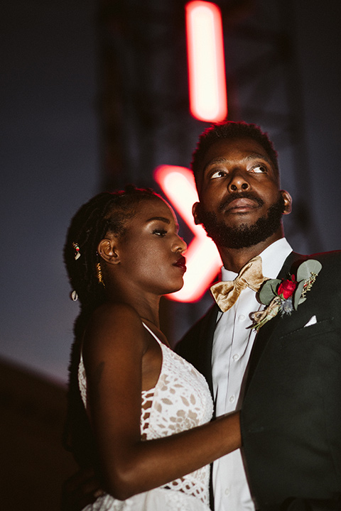  a chic LA studio shoot for a modern boho wedding – with the groom in a white lace gown and the groom in a green suit - bride