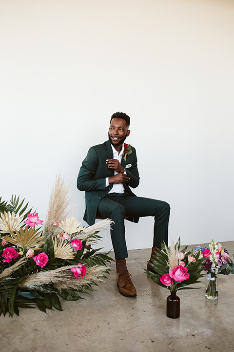  a chic LA studio shoot for a modern boho wedding – with the groom in a white lace gown and the groom in a green suit – groom