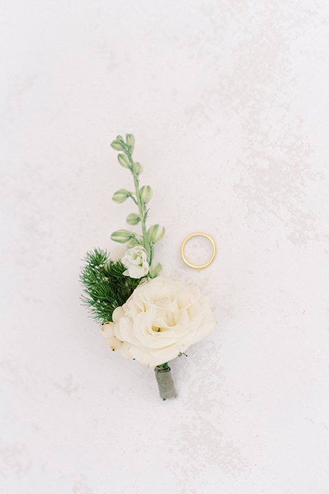  a romantic garden wedding at a Spanish inspired venue with the bride in a lace gown and the groom in a tan suit – boutonnière