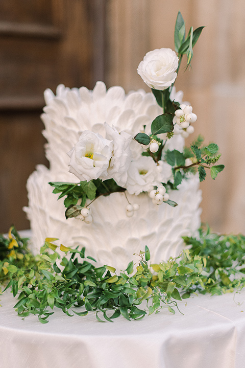  a romantic garden wedding at a Spanish inspired venue with the bride in a lace gown and the groom in a tan suit – cake