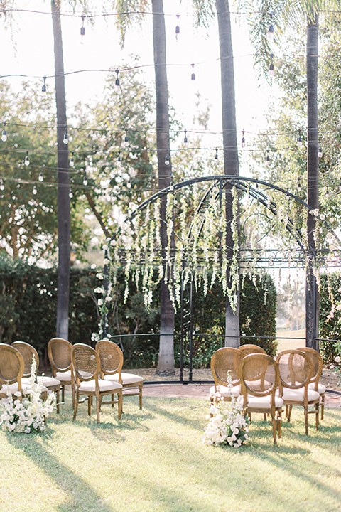  a romantic garden wedding at a Spanish inspired venue with the bride in a lace gown and the groom in a tan suit – ceremony décor